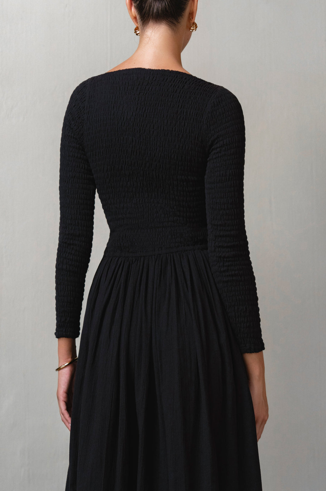 Black dress with long sleeves on a plain background