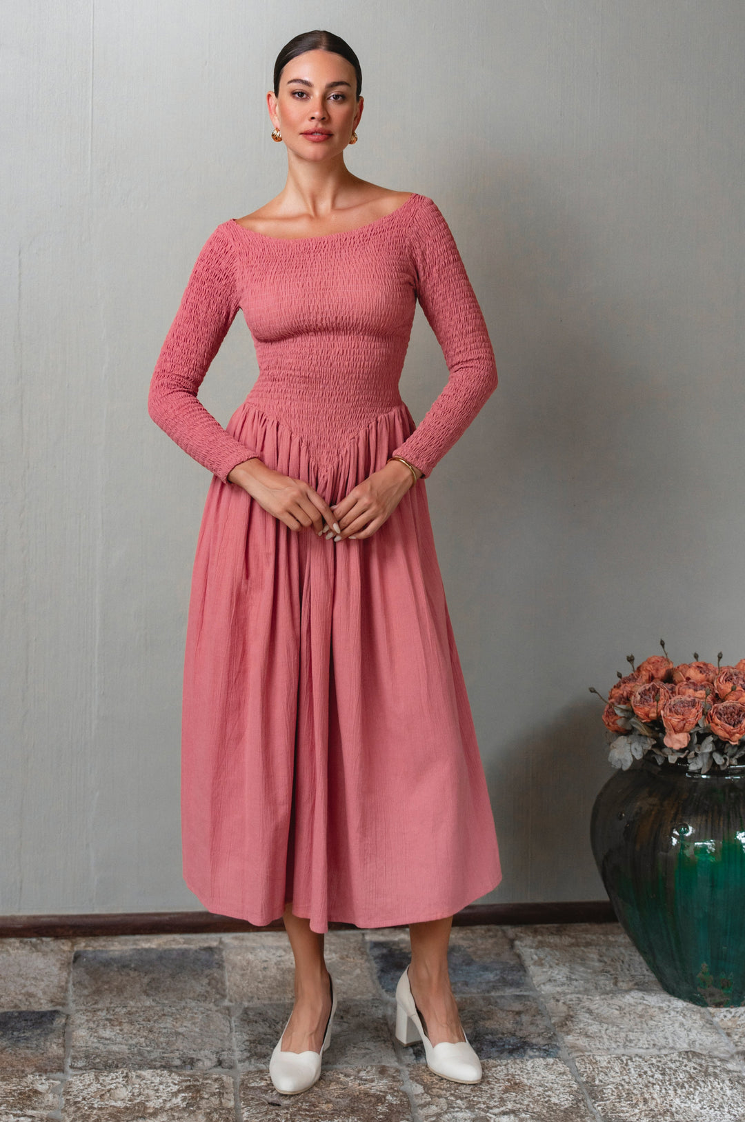 Person wearing a pink smocked long sleeve dress 