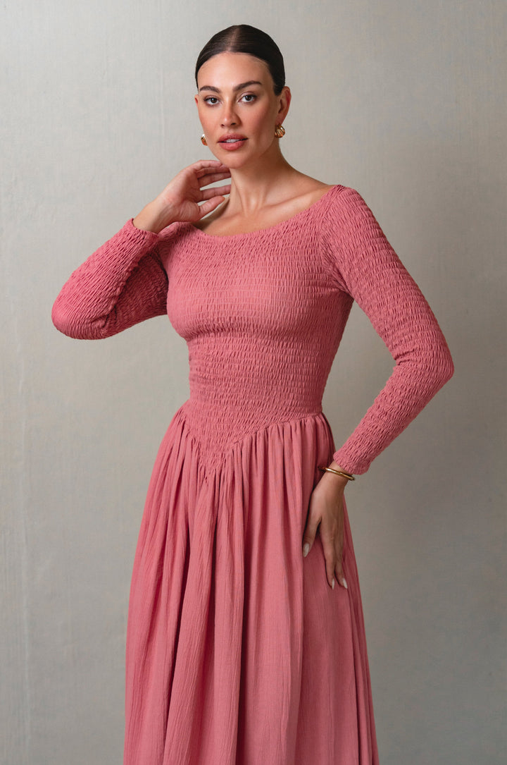 Woman wearing a pink dress against a plain background