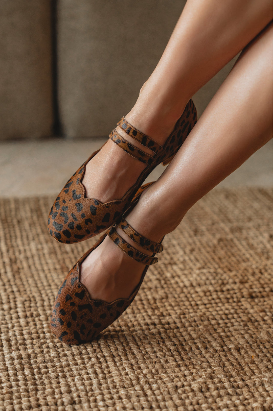 Leopard print shoes worn by a person on a textured surface