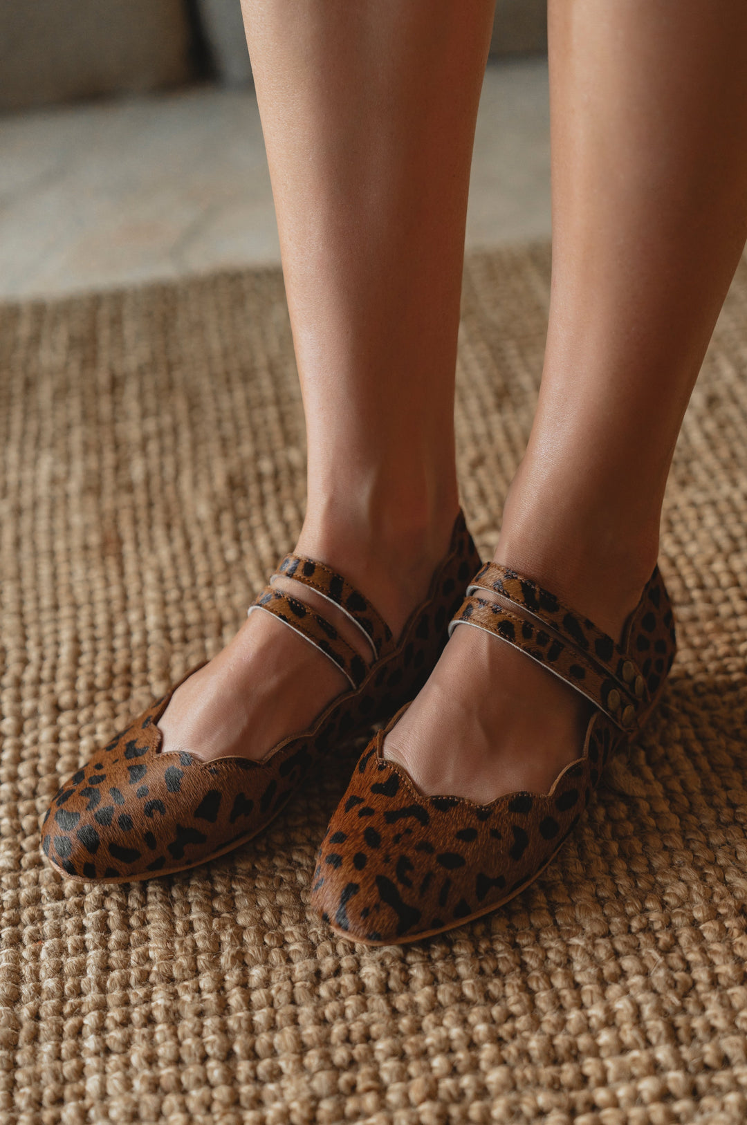 Leopard print shoes worn on a textured floor