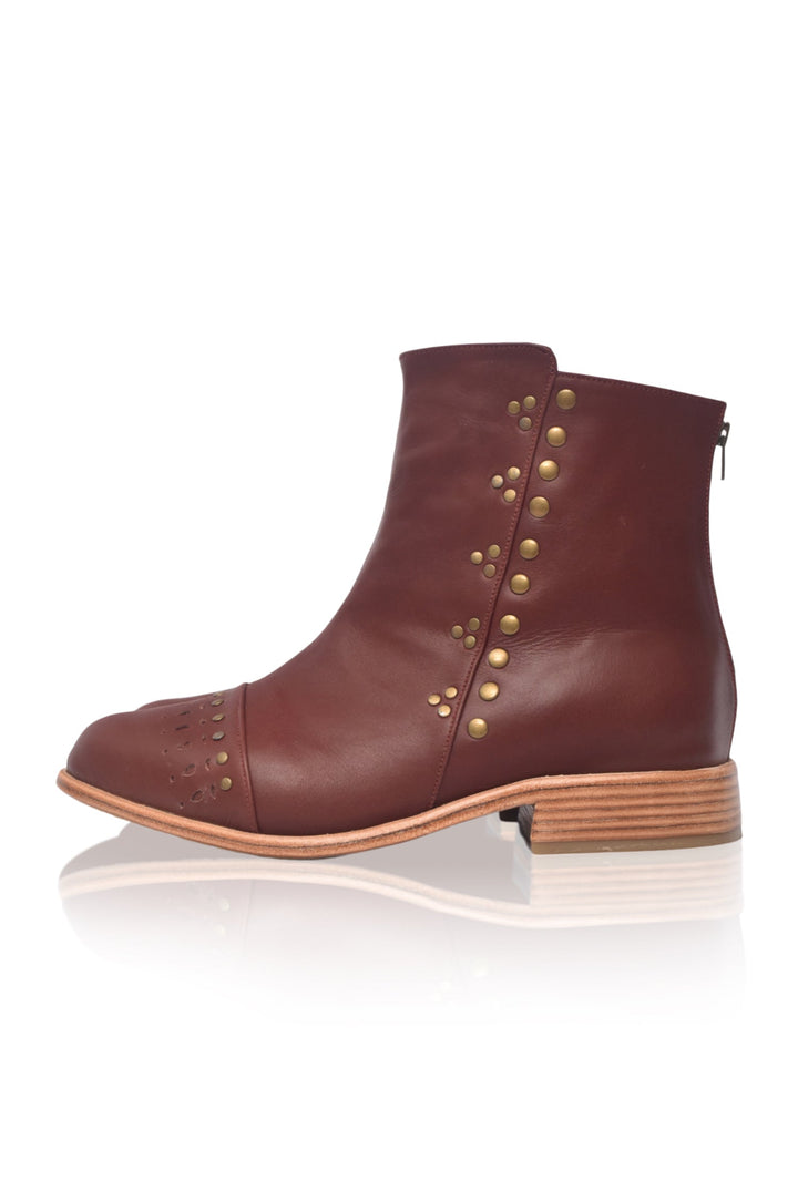 Brown ankle boot with gold studs on a white background
