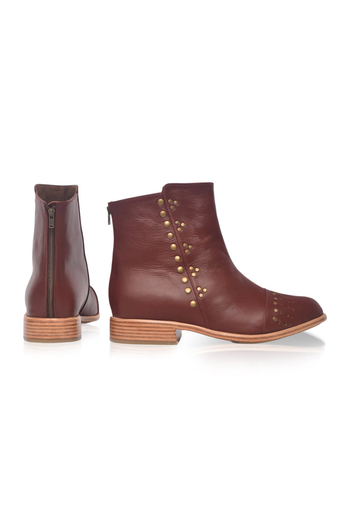 Brown leather boots with gold studs on a white background