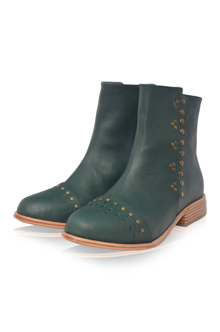 Pair of green ankle boots with brown soles on a white background