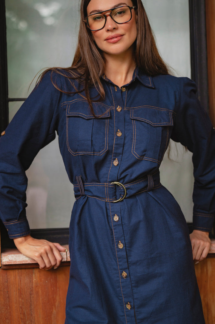 Woman wearing a blue denim dress with a belt, standing indoors - cottage core style