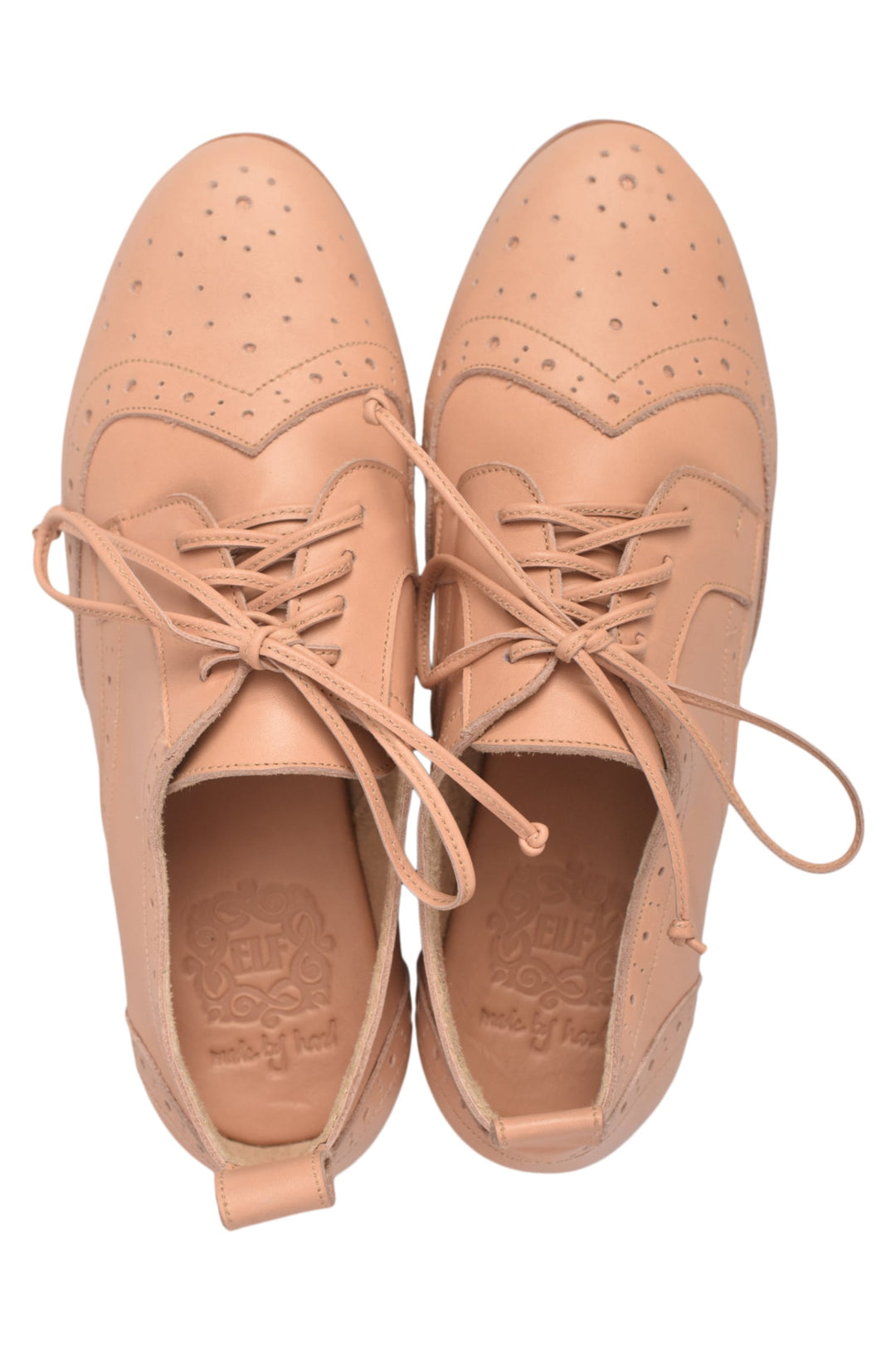 Pair of tan leather shoes with laces on a white background