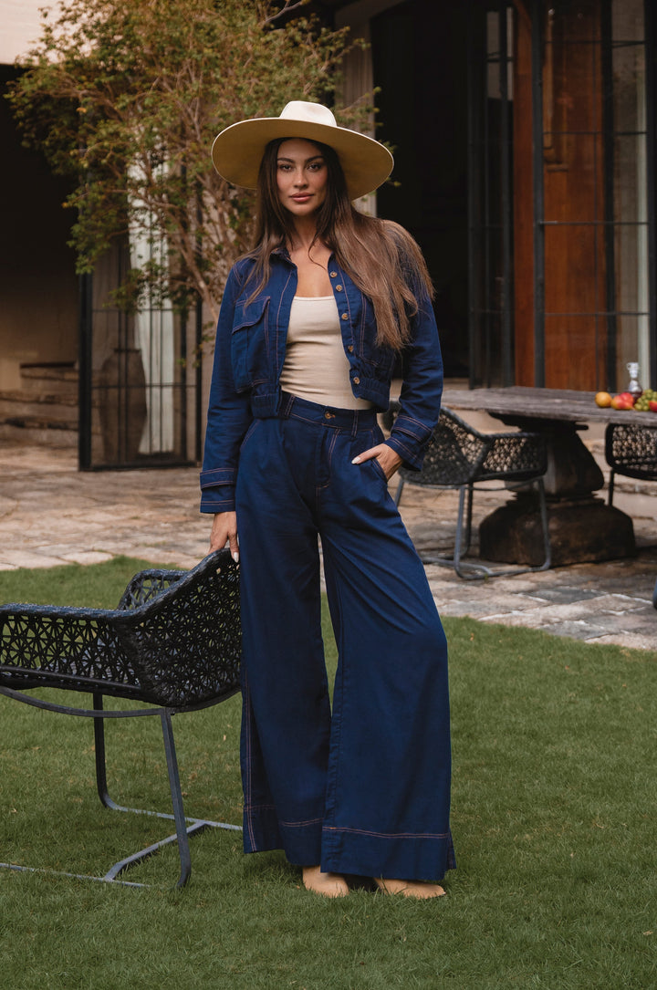 Woman in a blue linen set with a wide-brimmed hat standing outdoors - cottage core style