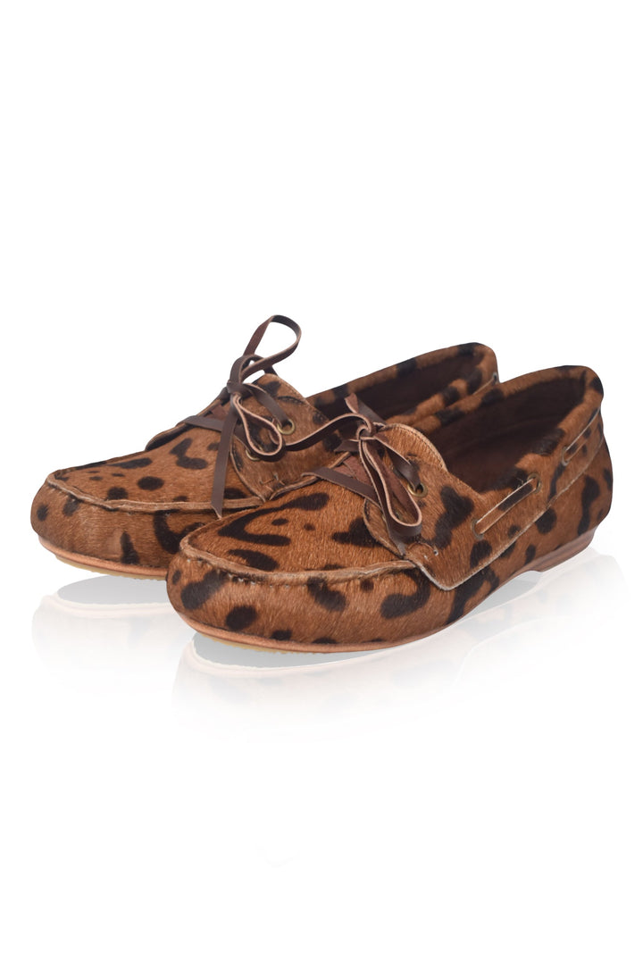 Pair of brown loafers with black spots on a white background