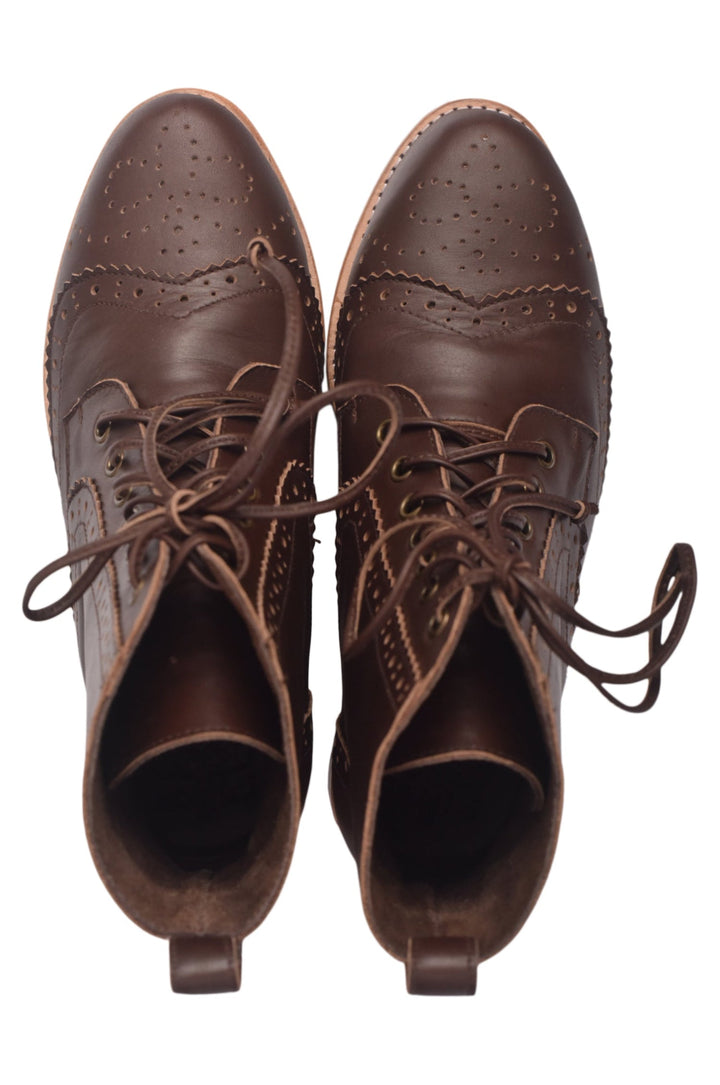 Pair of brown leather boots with laces on a white background